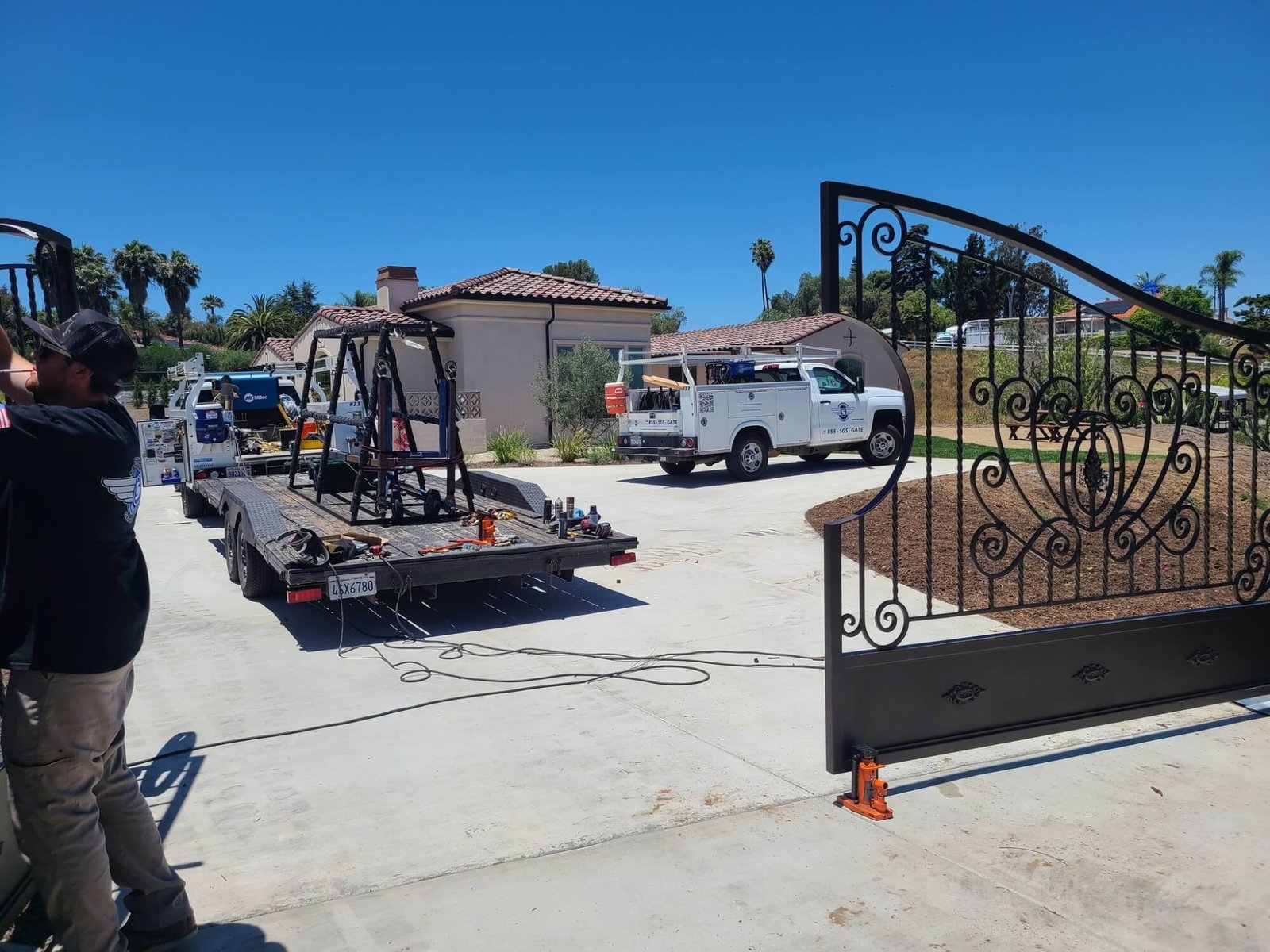 Gate Service & Install in Fort Worth - TX as a technician adjusts a residential driveway gate