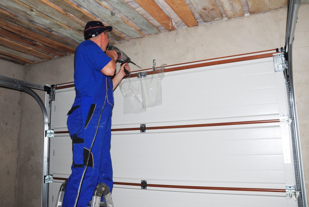 Gate Service & Install in Fort Worth - TX as a technician adjusts a residential driveway gate, Technician performing Garage Door Repair on a jammed residential door in Fort Worth - TX driveway