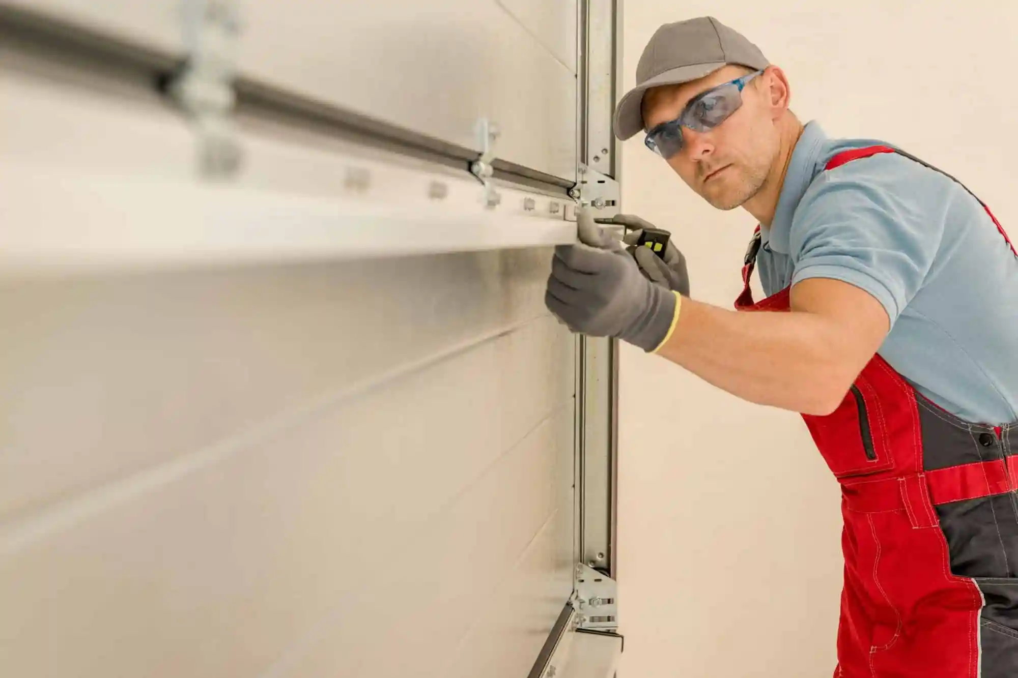 Garage Door Repair & Maintenance in Fort Worth - TX as a technician adjusts tracks on a stuck garage door, Specialist completing Garage Door Installation on a North Richland Hills - TX home while checking spring tension